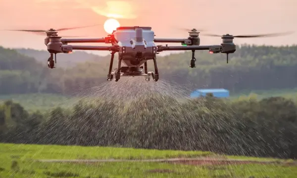 Drone with spreader attachment distributing granular material